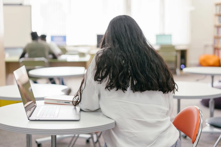 Studente sorridente con un laptop in un ambiente moderno